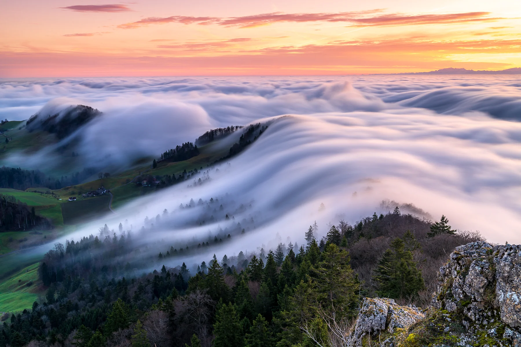 Dramatisches Nebelmeer mit Wolkenwellen bei Sonnenaufgang über dem Belchenflue, Baselland, Blick von Berggipfel