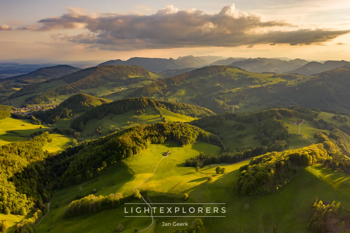 Luftaufnahme Belchenflue Baselland im Frühling — grüne Hügellandschaft mit goldenem Sonnenuntergang und Alpenpanorama, Lightexplorers Fotoworkshop