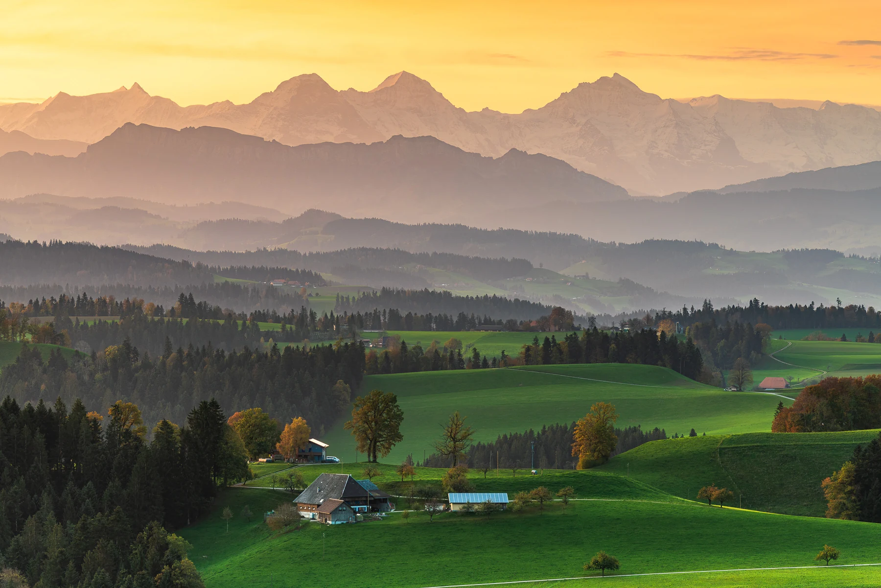 Emmental Hügellandschaft mit epischem Alpenblick auf Eiger, Mönch und Jungfrau im orange-goldenen Sonnenuntergang, Bauernhöfe, Kanton Bern — Lightexplorers Fotoworkshop