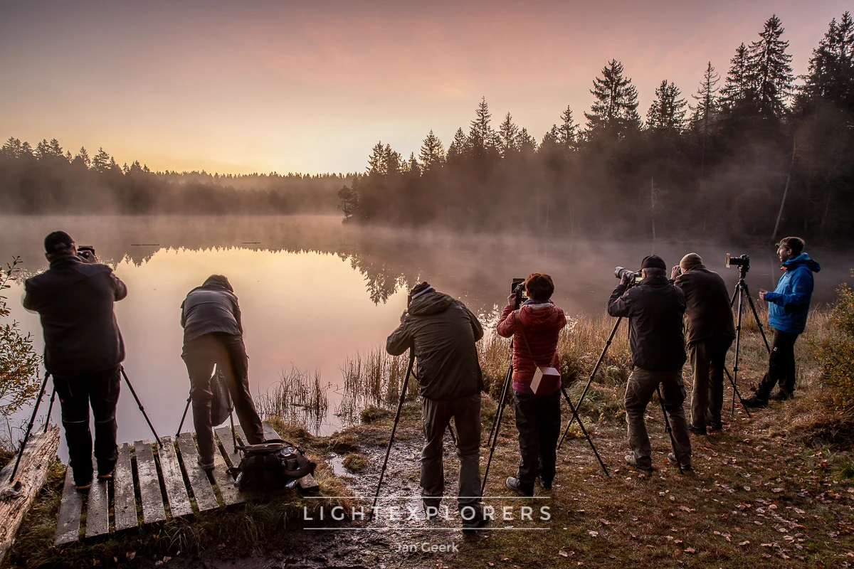 Gruppe von Fotografen mit Stativen an nebligem Bergsee bei rosa Morgendämmerung — Lightexplorers Fotoworkshop Schweiz mit Kevin Buess und Jan Geerk